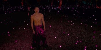Movie still from “Savage x Fenty Show Vol. 4” (2022), directed by Alex Rudzinski – A man standing in front of a field of lights at night; Wide shot, High angle