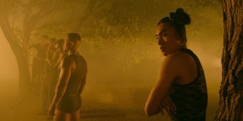 Movie still from “Savage x Fenty Show Vol. 4” (2022), directed by Alex Rudzinski – A man and a woman standing next to each other in a forest; Medium shot, Over the shoulder angle