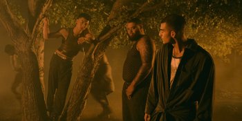 Movie still from “Savage x Fenty Show Vol. 4” (2022), directed by Alex Rudzinski – A group of men standing next to a tree; Medium shot, Low angle