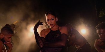 Movie still from “Savage x Fenty Show Vol. 4” (2022), directed by Alex Rudzinski – A woman in a black dress and black gloves; Medium shot, Low angle
