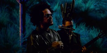 Movie still from “Savage x Fenty Show Vol. 4” (2022), directed by Alex Rudzinski – A man in a leather jacket and a man in a rabbit mask; Medium shot, Low angle