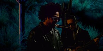 Movie still from “Savage x Fenty Show Vol. 4” (2022), directed by Alex Rudzinski – A man with a microphone and another man with a microphone; Medium shot, Low angle