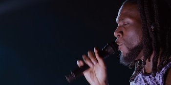 Movie still from “Savage x Fenty Show Vol. 4” (2022), directed by Alex Rudzinski – A person holding a microphone up to their mouth; Close Up shot, Low angle