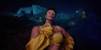 Movie still from “Savage x Fenty Show Vol. 4” (2022), directed by Alex Rudzinski – A woman in a yellow outfit posing for a picture; Medium shot, Low angle