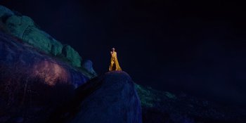 Movie still from “Savage x Fenty Show Vol. 4” (2022), directed by Alex Rudzinski – A man standing on top of a rock at night; Extreme Wide shot, Low angle