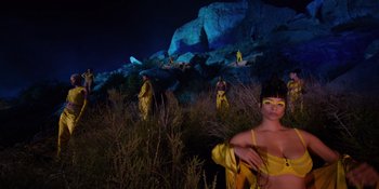 Movie still from “Savage x Fenty Show Vol. 4” (2022), directed by Alex Rudzinski – A group of people standing in the grass at night; Extreme Wide shot, Low angle