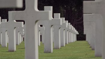 Movie still from “Saving Private Ryan” (1998), directed by Steven Spielberg – A row of white crosses in the grass; Extreme Wide shot, High angle