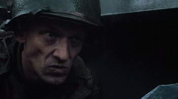 Movie still from “Saving Private Ryan” (1998), directed by Steven Spielberg – A man wearing a helmet and looking at the camera; Close Up shot, Low angle