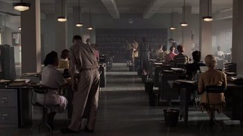 Movie still from “Saving Private Ryan” (1998), directed by Steven Spielberg – A group of people sitting at tables in a room; Wide shot, High angle