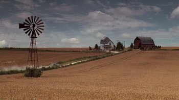 Movie still from “Saving Private Ryan” (1998), directed by Steven Spielberg – An image of a farm with a windmill in the background; Extreme Wide shot, High angle