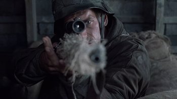 Movie still from “Saving Private Ryan” (1998), directed by Steven Spielberg – A man wearing a hat and holding a gun; Close Up shot, Over the shoulder angle