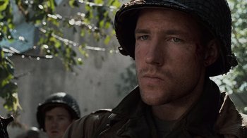 Movie still from “Saving Private Ryan” (1998), directed by Steven Spielberg – A man wearing a helmet and a camouflage uniform; Close Up shot, Low angle