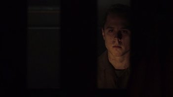 Movie still from “Saving Private Ryan” (1998), directed by Steven Spielberg – A man in a dark room looking at the camera; Close Up shot, Low angle