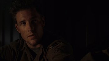 Movie still from “Saving Private Ryan” (1998), directed by Steven Spielberg – A man in a military uniform sitting in a dark room; Close Up shot, Low angle