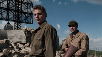 Movie still from “Saving Private Ryan” (1998), directed by Steven Spielberg – Two men standing next to each other on a rocky ground; Medium shot, Low angle