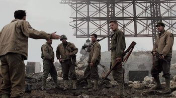 Movie still from “Saving Private Ryan” (1998), directed by Steven Spielberg – A group of men standing next to each other on a field; Medium shot, Over the shoulder angle