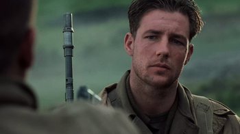 Movie still from “Saving Private Ryan” (1998), directed by Steven Spielberg – A person holding a gun; Close Up shot, Over the shoulder angle