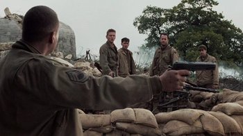 Movie still from “Saving Private Ryan” (1998), directed by Steven Spielberg – A group of men standing next to each other in a field; Medium shot, Over the shoulder angle