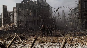 Movie still from “Saving Private Ryan” (1998), directed by Steven Spielberg – A group of men standing next to barbed wire; Extreme Wide shot, Low angle