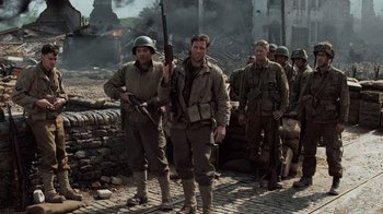 Movie still from “Saving Private Ryan” (1998), directed by Steven Spielberg – A group of men standing next to each other holding guns; Medium shot, Over the shoulder angle