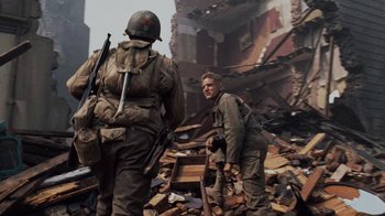 Movie still from “Saving Private Ryan” (1998), directed by Steven Spielberg – Two men in military fatigues are standing in the rubble; Medium shot, Low angle