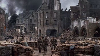 Movie still from “Saving Private Ryan” (1998), directed by Steven Spielberg – A group of men walking across a dirt road; Extreme Wide shot, High angle