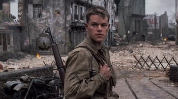 Movie still from “Saving Private Ryan” (1998), directed by Steven Spielberg – A man with a gun standing next to a building; Medium shot, Low angle