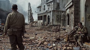 Movie still from “Saving Private Ryan” (1998), directed by Steven Spielberg – An image of a man walking through the ruins of a city; Wide shot, Low angle