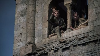 Movie still from “Saving Private Ryan” (1998), directed by Steven Spielberg – A man sitting on top of a window ledge; Medium shot, Low angle