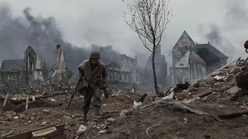 Movie still from “Saving Private Ryan” (1998), directed by Steven Spielberg – A man in a helmet is walking through the ruins; Wide shot, High angle