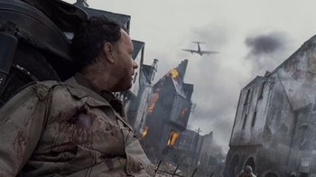 Movie still from “Saving Private Ryan” (1998), directed by Steven Spielberg – An image of a man that is looking at a plane in the sky; Medium shot, Over the shoulder angle