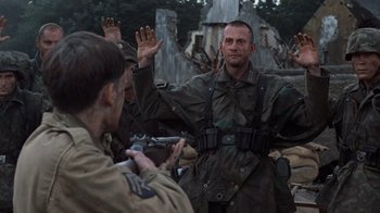 Movie still from “Saving Private Ryan” (1998), directed by Steven Spielberg – A group of men standing next to each other; Medium shot, Over the shoulder angle