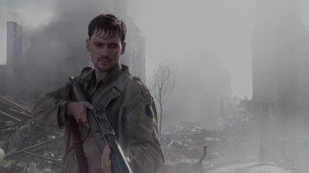 Movie still from “Saving Private Ryan” (1998), directed by Steven Spielberg – A man holding a rifle in a war scene; Close Up shot, Over the shoulder angle