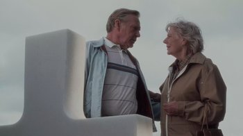 Movie still from “Saving Private Ryan” (1998), directed by Steven Spielberg – An older man and a younger woman standing next to each other; Medium shot, Low angle