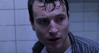 Movie still from “Saw” (2004), directed by James Wan – A person with wet hair; Close Up shot, Low angle
