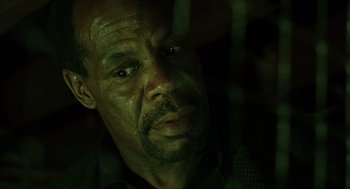 Movie still from “Saw” (2004), directed by James Wan – A person looking at the camera; Close Up shot, Low angle