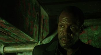 Movie still from “Saw” (2004), directed by James Wan – A person in a dark room; Close Up shot, Low angle