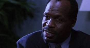 Movie still from “Saw” (2004), directed by James Wan – A man in a suit and tie looking to his left; Close Up shot, Low angle
