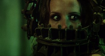 Movie still from “Saw” (2004), directed by James Wan – A person wearing a metal mask; Close Up shot, Low angle