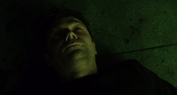 Movie still from “Saw” (2004), directed by James Wan – A man sleeping in the dark with his eyes closed; Close Up shot, Overhead angle