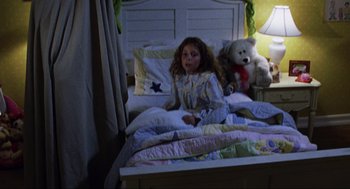 Movie still from “Saw” (2004), directed by James Wan – A little girl sitting on a bed with a teddy bear; Medium shot, High angle