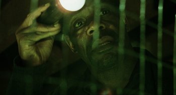 Movie still from “Saw” (2004), directed by James Wan – A person looking through a window; Close Up shot, Low angle