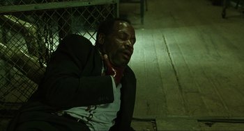 Movie still from “Saw” (2004), directed by James Wan – A man sitting on the ground with his eyes closed; Close Up shot, High angle