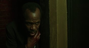 Movie still from “Saw” (2004), directed by James Wan – A man with blood on his face and hand; Close Up shot, Low angle