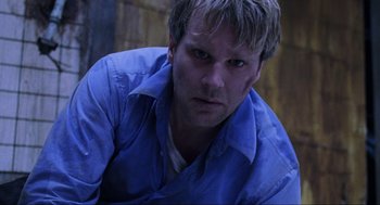 Movie still from “Saw” (2004), directed by James Wan – A person wearing a blue shirt; Close Up shot, Overhead angle