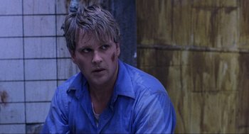 Movie still from “Saw” (2004), directed by James Wan – A person wearing a blue shirt; Close Up shot, Over the shoulder angle