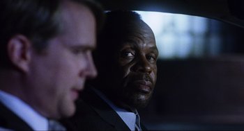Movie still from “Saw” (2004), directed by James Wan – A man in a suit and tie next to another man in a suit and tie; Close Up shot, Over the shoulder angle