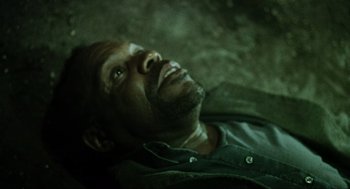 Movie still from “Saw” (2004), directed by James Wan – A person laying on the ground; Close Up shot, Overhead angle