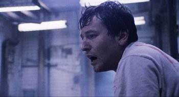 Movie still from “Saw” (2004), directed by James Wan – A person with wet hair; Close Up shot, Low angle