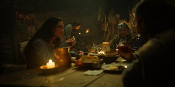 Movie still from “Sayen” (2023), directed by Alexander Witt – A group of people sitting at a table with food; Medium shot, Over the shoulder angle